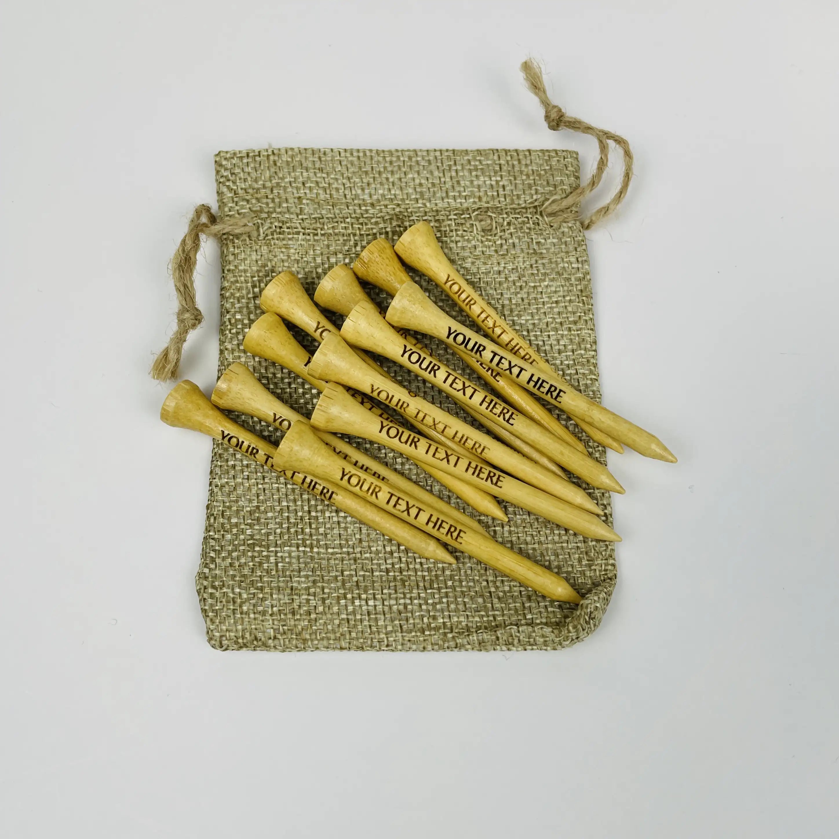 Personalized wooden golf tees with a drawstring bag on a light gray background