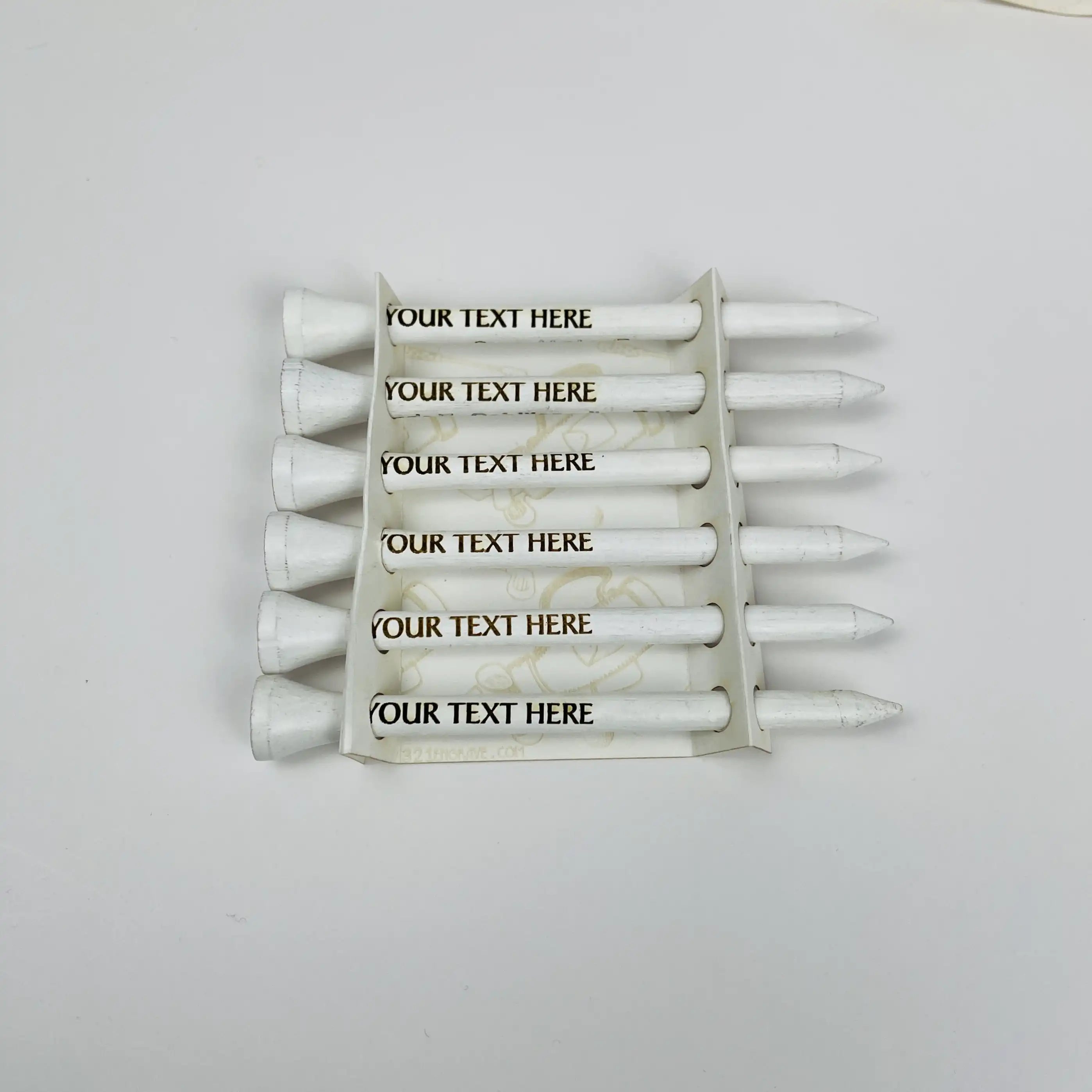 White golf tees with customizable text on a white background