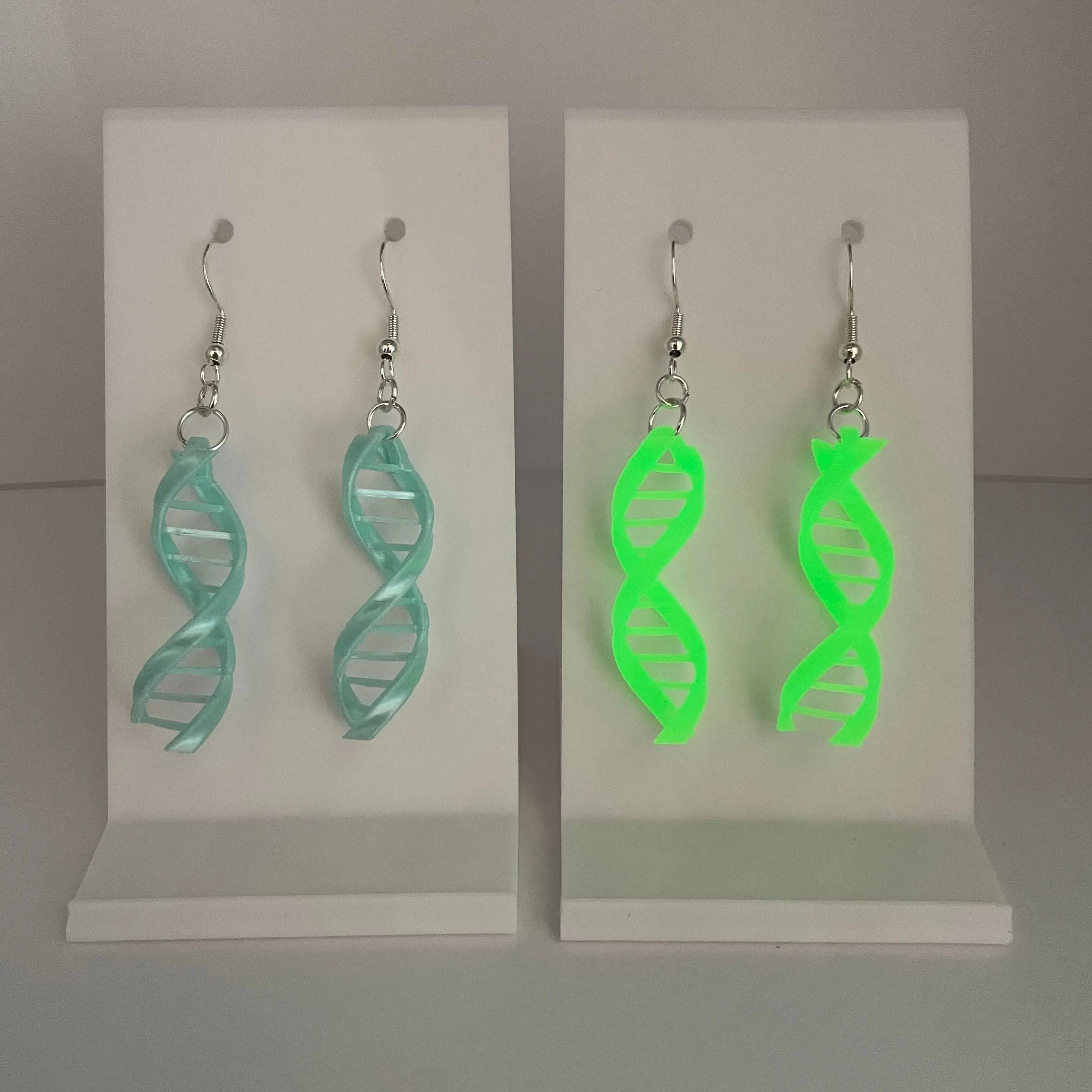 Double Helix DNA Dangle Earrings come in a shimmering light blue color and a glow-in-the-dark green.